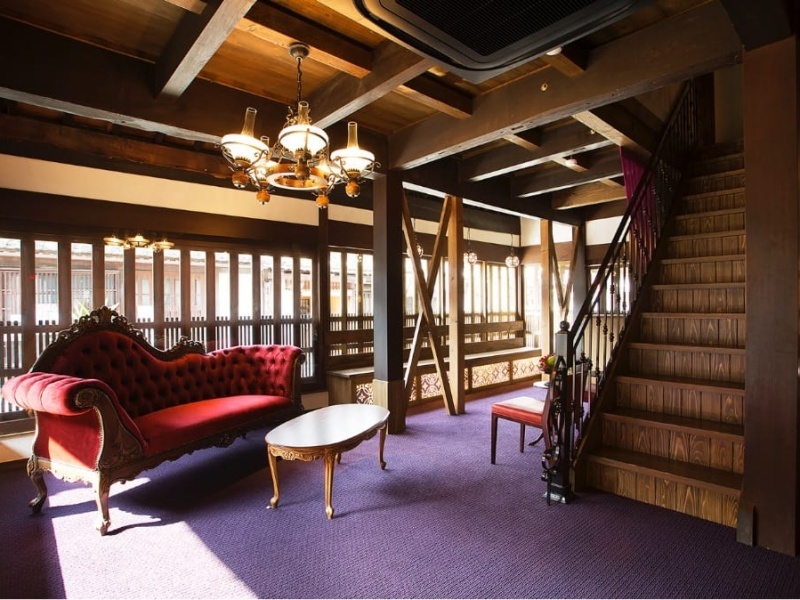 木の梁と赤いソファが調和する、レトロモダンな空間。今昔が溶け合う、華紋ならではの雰囲気が漂います。