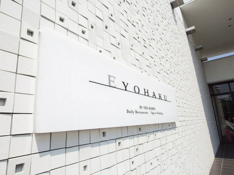 白を基調とした清潔感あるエントランスに刻まれたEYOHAKUのロゴ。訪れるゲストを上質な空間へと誘う、品格あるたたずまいです。
