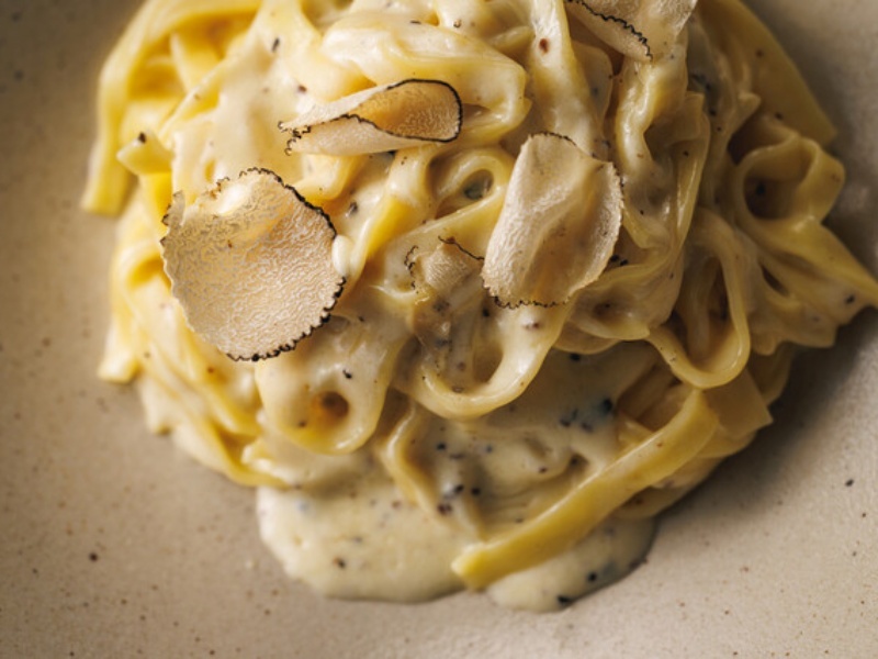 たっぷりのトリュフをのせた濃厚なパスタ。トリュフの香りと旨みが堪能できる贅沢な一皿です。
